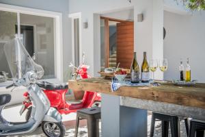 a motor scooter parked next to a table with wine glasses at The Whale on Main B&B in Hermanus