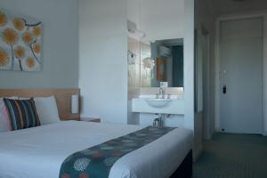 Habitación de hotel con cama y lavabo en Markets Hotel en Sídney