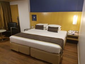 ein Schlafzimmer mit einem großen Bett in einem Hotelzimmer in der Unterkunft Ramee Guestline Hotel Dadar in Mumbai