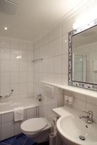 a bathroom with a toilet and a sink and a mirror at Appartements Hotel-Garni Dolce Vita in Samnaun