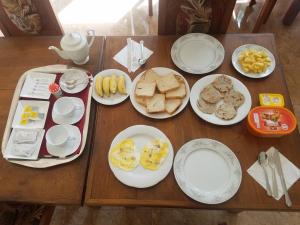 una mesa de madera con platos de desayuno. en Mermaid Inn, en Mirissa