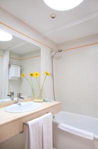a bathroom with a sink and a tub and a mirror at H10 Suites Lanzarote Gardens in Costa Teguise
