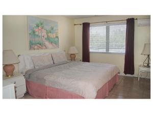 a bedroom with a bed and two lamps and a window at Viceroy 101 in Freeport