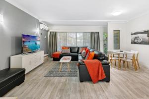 sala de estar con sofá y mesa en Smugglers On The Beach, en Coffs Harbour