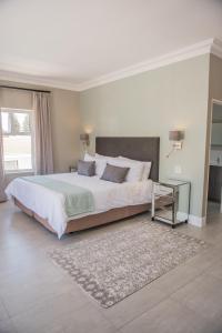 a large bedroom with a large bed and a rug at The Whale on Main B&B in Hermanus