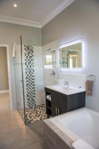 a bathroom with a sink and a mirror at The Whale on Main B&B in Hermanus