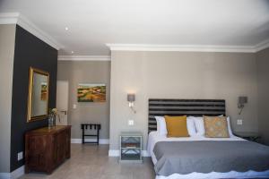 a bedroom with a large bed with yellow pillows at The Whale on Main B&B in Hermanus