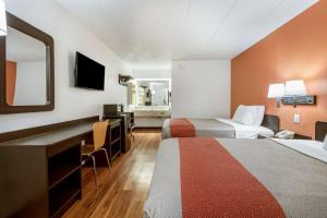 Habitación de hotel con 2 camas, escritorio y espejo. en Motel 6-Grove City, OH, en Grove City
