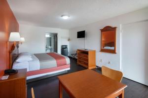a small hotel room with a bed and a desk at Motel 6-Montgomery, AL - Coliseum in Montgomery