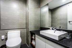 a bathroom with a white toilet and a sink at Vistacay Hotel Worldcup in Seogwipo +80 photos