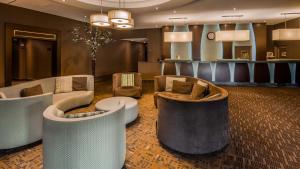 a lobby with couches and chairs and a bar at Best Western Plus Guildwood Inn in Sarnia