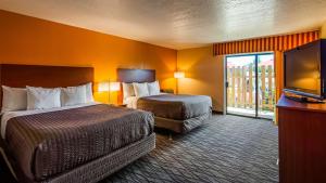 a hotel room with two beds and a flat screen tv at SureStay Hotel by Best Western Wenatchee in Wenatchee
