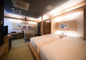 松山市にあるCHAHARU 離れ 道後 夢蔵のベッドとテレビがあるホテルの部屋