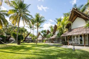 een uitzicht op het terrein van een resort met palmbomen bij La Pirogue Mauritius in Flic-en-Flac