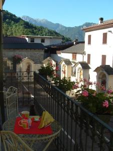 a balcony with a table with a plate of food at La Ca' Di Sala in Margno