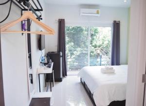 黎府的住宿－Kangsadan Resort，一间卧室设有一张床和一个大窗户