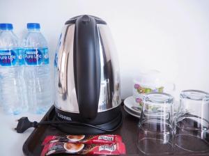 Eine Kaffeemaschine steht mit Wasserflaschen auf der Küchentheke. in der Unterkunft Kangsadan Resort in Loei