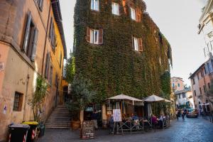 een gebouw met klimop aan de zijkant bij JUSTACASA alla SCALA Trastevere in Rome