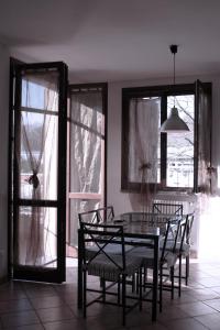 a dining room with a table and chairs and windows at Hotel La Rosta in Reggio Emilia