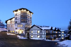 Un gran edificio con luces en la nieve. en Dorint Resort Winterberg, en Winterberg