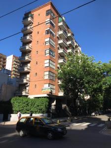 une voiture noire garée devant un grand bâtiment dans l'établissement Apartamento Bulnes y Calle Corrientes, à Buenos Aires