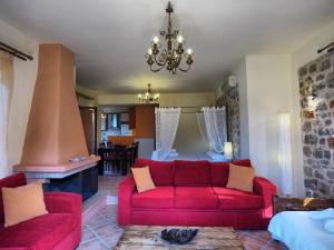 uma sala de estar com um sofá vermelho e uma lareira em Sophia Limeni View em Limeni