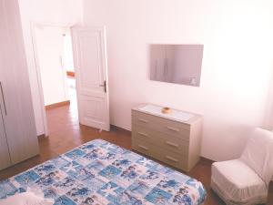 a room with a bed and a dresser and a tv at Appartamento centralissimo a Tortolì! 75mq in Tortolì