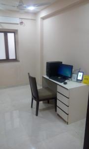 an office with a desk with a laptop and a chair at Treebo Trend Vedanta in Kolkata