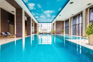 a large swimming pool with a mural of a sky at Beijing Hotel Minsk in Minsk