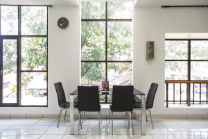 a dining room with a table and chairs and windows at RedDoorz near Eka Hospital BSD City in Tangerang