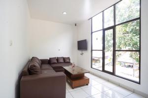 a living room with a couch and a large window at RedDoorz near Eka Hospital BSD City in Tangerang