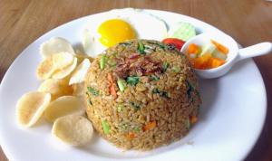 a plate of food with rice and eggs and vegetables at Amerta Home Stay Bali in Denpasar