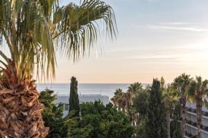 a view of the ocean from a palm tree at Poseidon's Luxury Apartment in Paphos