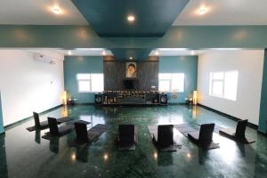 parkiet taneczny z czarnymi krzesłami w pokoju w obiekcie Osho Glimpse Mysore w mieście Mysuru