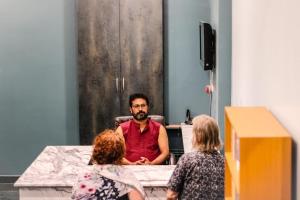 um homem sentado numa mesa com duas mulheres em Osho Glimpse Mysore em Mysore