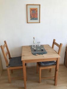 einen Holztisch mit zwei Stühlen, einem Tisch und einem Bild in der Unterkunft Cosy Flora Nest in Prag