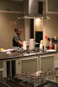 a woman standing in a kitchen preparing food at Nauntons Guest House & Wedding Venue in Ladysmith