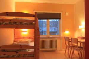 Abisko net Hostel & Huskies في أبيسكو: غرفة نوم مع سرير بطابقين وطاولة وكراسي