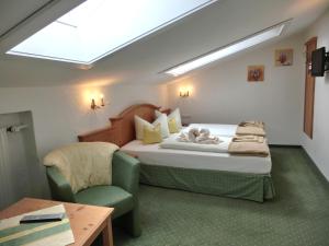 - une chambre avec un lit, une chaise et une table dans l'établissement Hotel-Garni Drachenburg, à Mittenwald