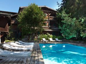 a resort with lounge chairs and a swimming pool at Fer à Cheval in Megève