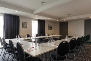 a conference room with long tables and chairs at The Originals City, Hôtel Acadine, Le Neubourg (Inter-Hotel) in Le Neubourg