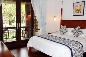 a bedroom with a large bed and a large window at The Patra Bali Resort & Villas - CHSE Certified in Kuta
