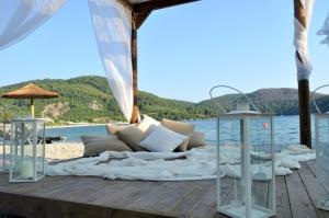 a bed on a wooden deck next to the water at Blue Green Bay in Panormos Skopelos