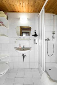 a white bathroom with a sink and a shower at Ferienwohnung Haus Lehen in Sankt Koloman
