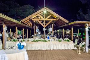 a banquet hall with white tables and chairs at night at Blue Green Bay in Panormos Skopelos