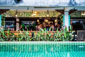 a restaurant with a pool in front of a bar at Chedi Home -SHA Extra Plus in Chiang Mai
