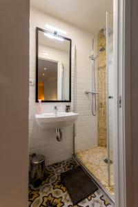 a bathroom with a sink and a shower with a mirror at Barbieri in Madrid