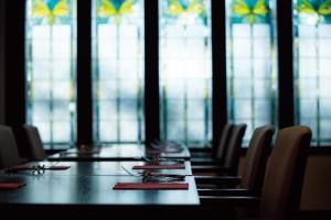 a long table in a room with chairs and windows at Kyoto Yamashina Hotel Sanraku in Kyoto