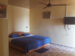 um quarto com 2 camas e uma ventoinha de tecto em IS Guest House em Cape Coast