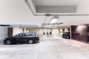 Un estacionamiento con dos coches estacionados en él en Adriano Residence, en Bolonia